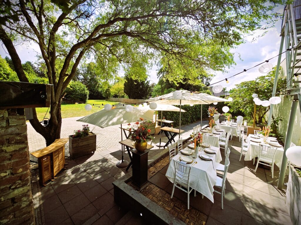 venue13-buiten-diner-terras-zomer-event Sfeervol buitendiner op het terras van Venue13 met lange tafels, geschikt voor zomerevenement of informele bruiloft