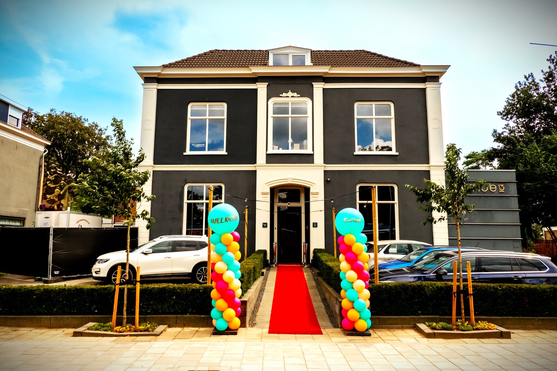 Entree van festival evenement bij Venue13 met rode loper en kleurrijke ballonpilaren