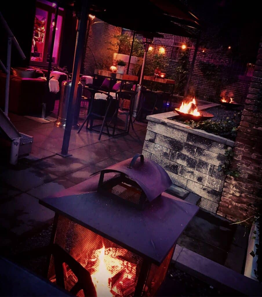venue13-terras-avondfeest-vuurkorf-buitenruimte-velp Buitenruimte van Venue13 in Velp met terras, vuurkorven en sfeerverlichting tijdens een avondfeest